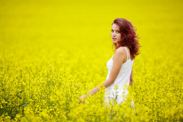 Naklejka na ściany i meble young beautiful girl in yellow field