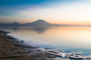 Beautiful sunrise scene at Sanur beach with the silhouette of Mount Agung, Bali, Indonesia. 