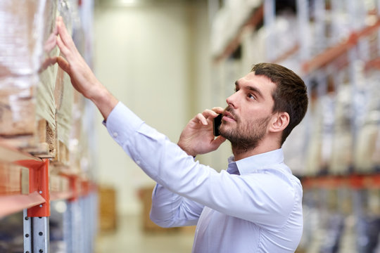 serious man calling on smartphone at warehouse