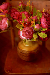 Bouquet flower in the vase on the brown background