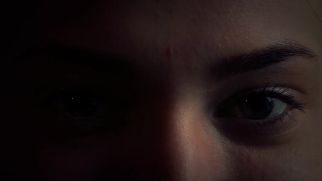 The girl's eyes in a dark room close up 5