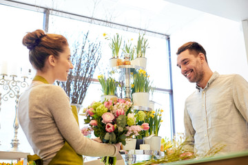 smiling florist woman and man at flower shop - obrazy, fototapety, plakaty