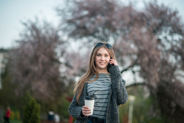 girl walking with coffee and phone