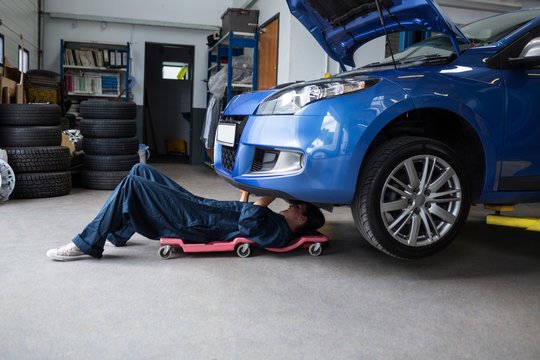 Female mechanic repairing a car