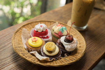 Cupcakes with iced latte on old wooden table.