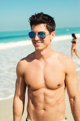 Handsome shirtless male portrait at beach.