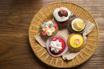Mixed cupcakes on wood table.