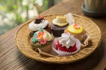 Cupcakes with hot chocolate on old wooden table.