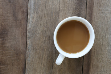 White coffee cup placed on the old wooden floor.