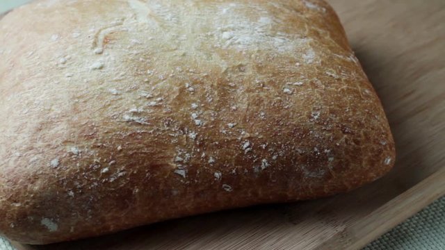 A loaf of white bread on wooden cutting board
