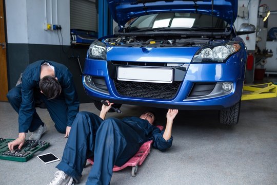 Mechanics repairing a car