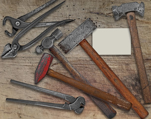 blacksmith tools and business card over bench