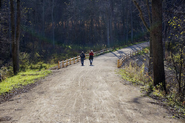 Senior couple walking down a wooded path.