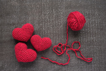 Crocheted red hearts on a grunge board