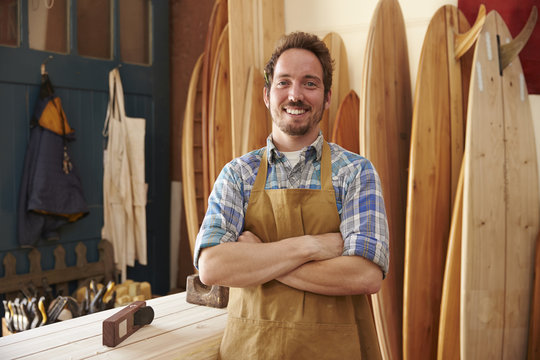 Portrait Of Carpenter Making Bespoke Surfboards In Workshop