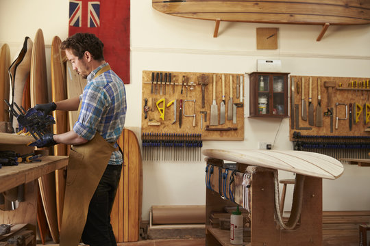Carpenter Building Bespoke Wooden Surfboard In Workshop