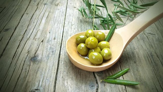 Olive oil drops on the spoon with olives 4K UHD video