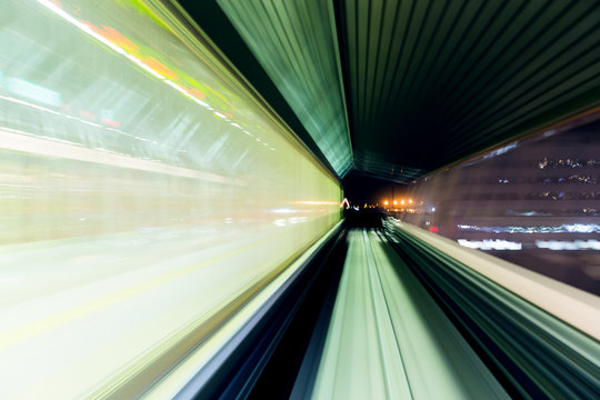Motion blur of a city and tunnel from inside a moving monorail