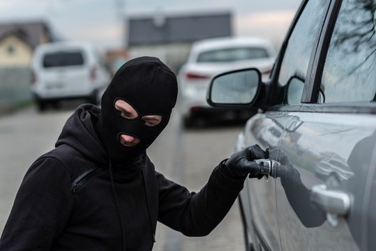 Car thief pulls the handle of a car.