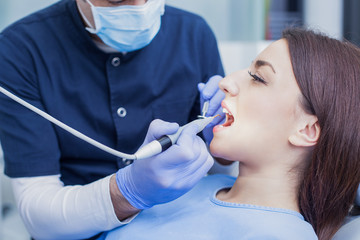 At the dentist. Male dentist in action