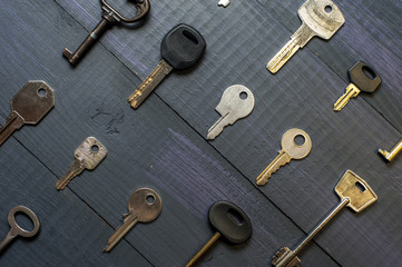 Many different keys on wooden background