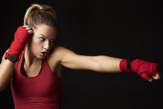 Young blonde woman shadow boxing with arm outstretched