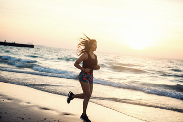 Fototapeta na wymiar Young woman running at beach.