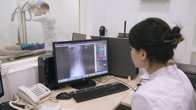 Two doctors examinting patient using xray
