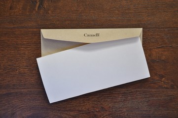 Brown envelope with Canada written to it and folded white paper