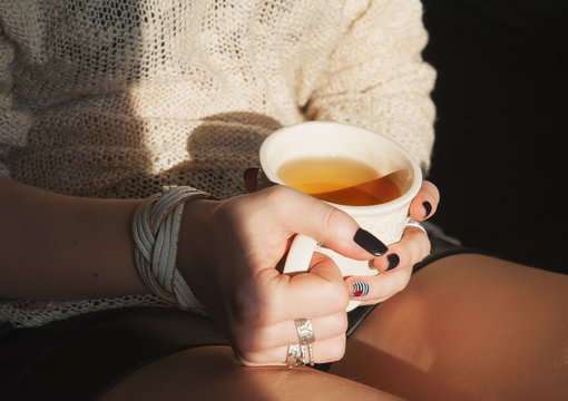 Woman relax with cup of tea in sunlight