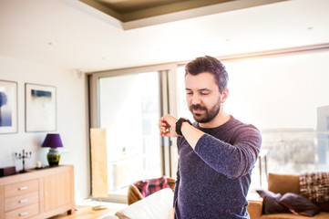 Man working from home using smart watch, living room