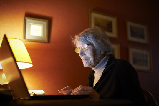 Senior Woman At Home Using Laptop Computer At Desk