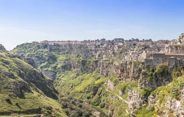 Fototapeta premium panoramic view of typical stones (Sassi di Matera) and church of Matera UNESCO European Capital of Culture 2019 under blue sky