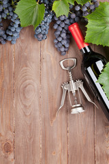 Red grape, wine bottle and corkscrew