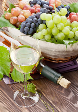White wine glass, bottle and grapes