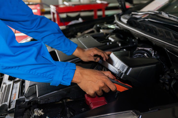 Mechanic checking and fixing a broken car in car service garage
