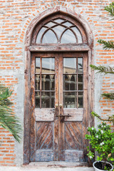 Fototapeta na wymiar The wooden front door of a home with glass panels to each side a