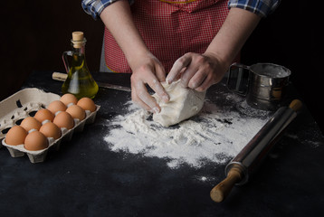 The process of preparing the dough. Men's hands knead the dough.