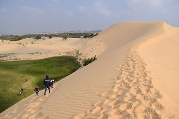 Fototapeta na wymiar traveller are discover in white sand dunes - Bau Trang, Mui Ne, Vietnam
