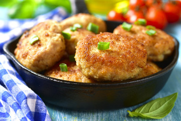 Chicken cutlets in a skillet.