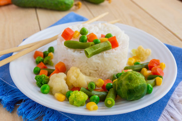 Rice with vegetables steamed on a white plate, laid out in a circle. Vegan