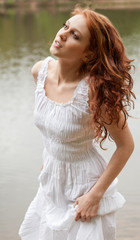 Fototapeta na wymiar Beautiful Woman in White Dress at Lake