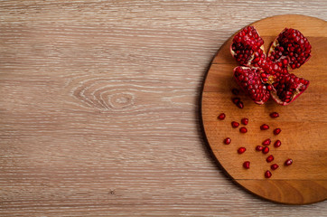 Ripe pomegranate on the wooden background