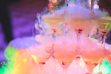 Beautiful pyramid line of multicolored different colored alcohol cocktails with mint on a tropical...