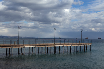 Obraz premium Przebijaj i statki na morzu. Nadmorska promenada w Limassol. Cypr.