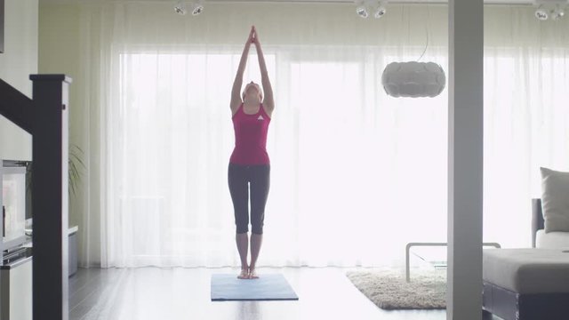 Young Woman doing Yoga at Living Room at Home. Shot on RED Cinema Camera.