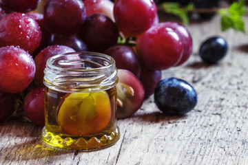 Essential oil of grape seeds and a fresh bunch of grapes, vintag