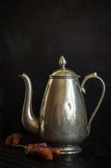 Food background with antique iron kettle and dates.