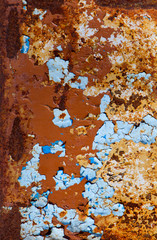 metal surface with peeling brown and blue paint