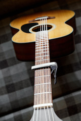 Acoustic guitar neck with a capo